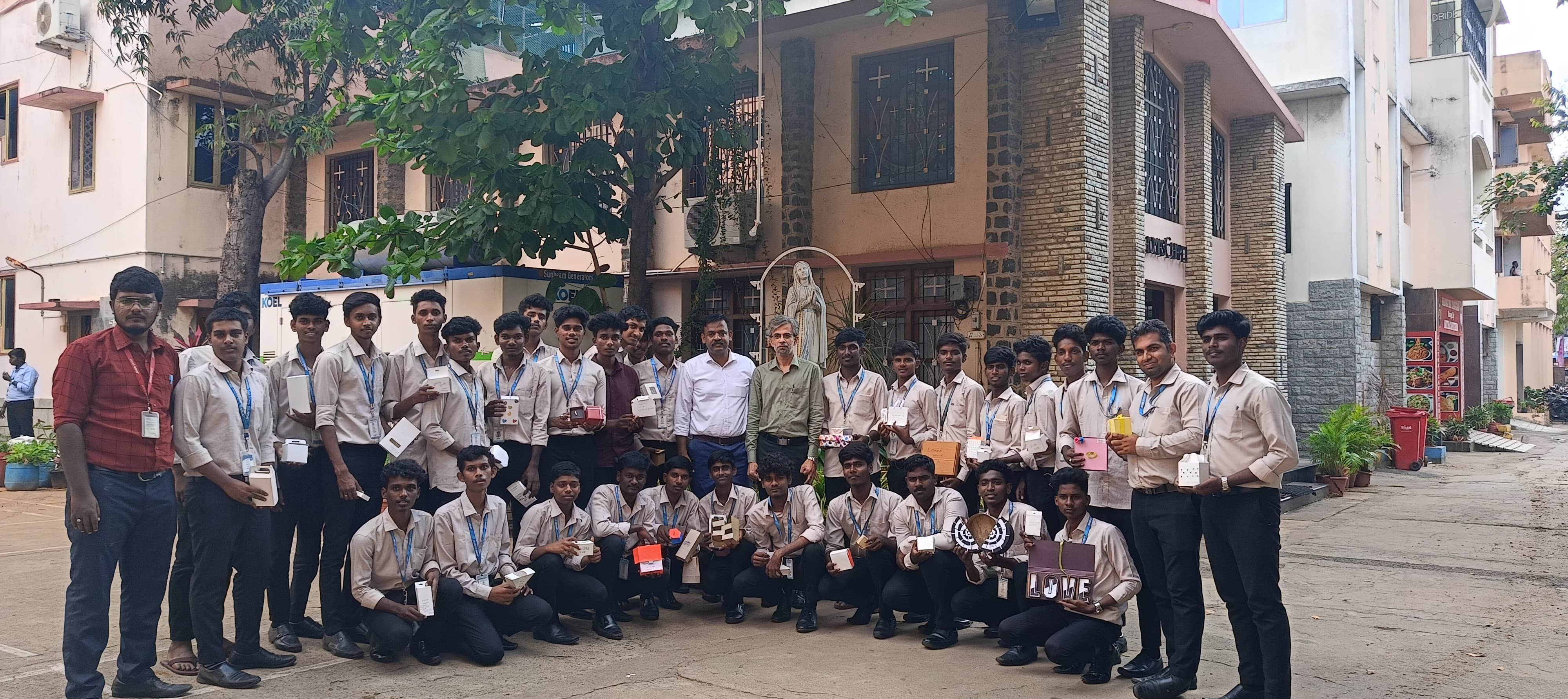 Jeetendra J with university students holding packaging projects outdoors