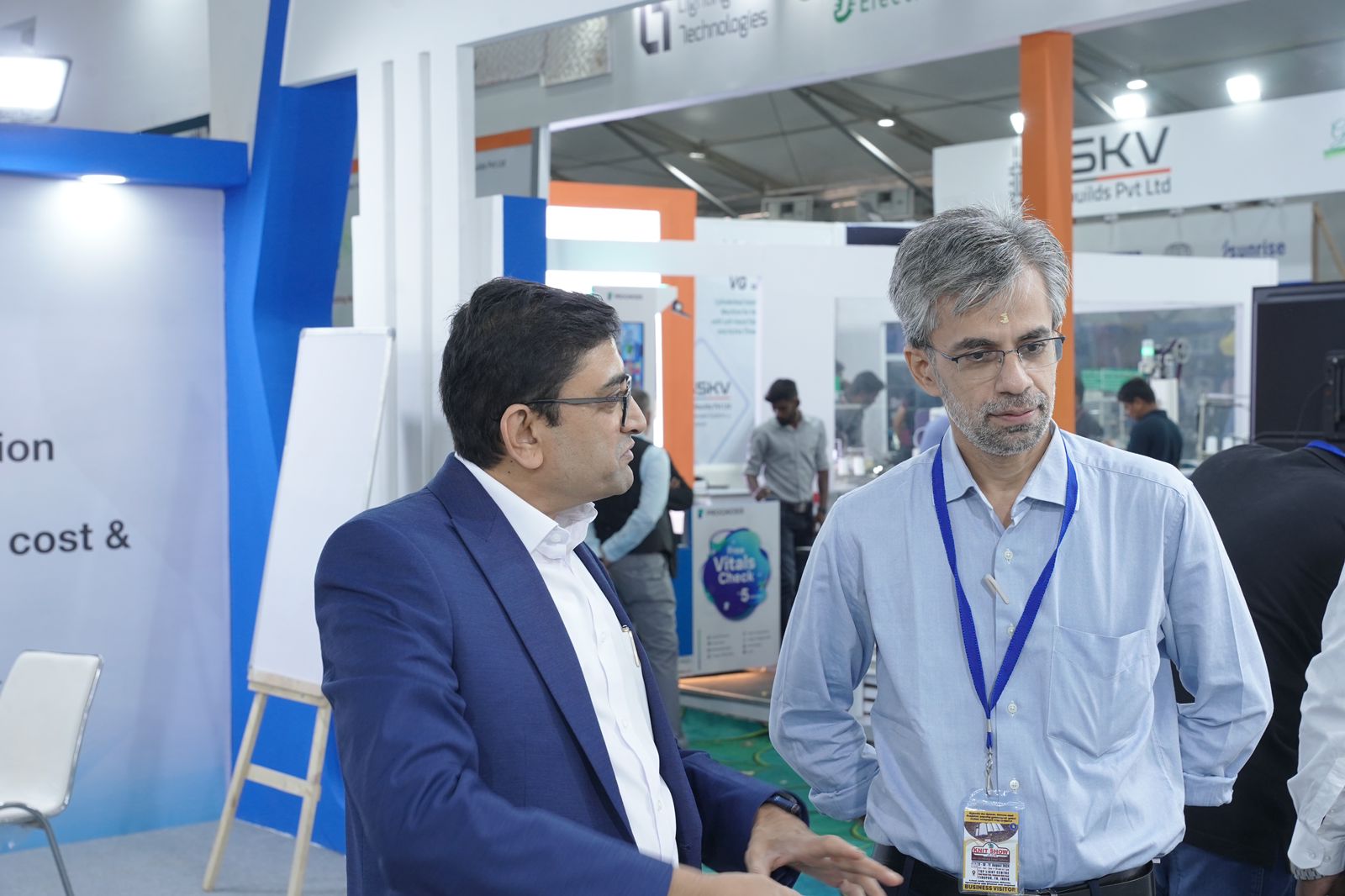 Jeetendra J consulting with an industry peer on an exhibition floor