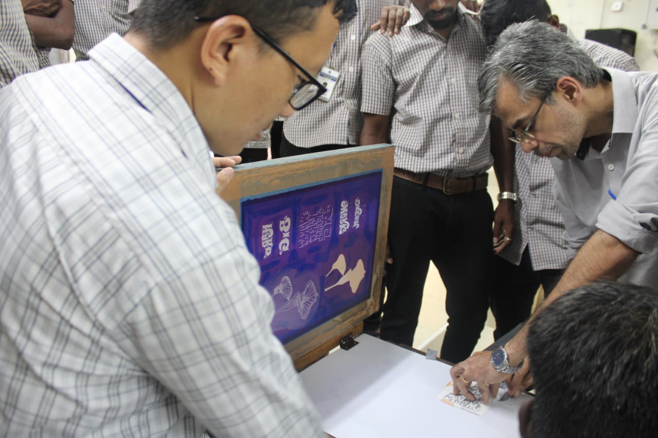 Jeetendra J demonstrating hands-on screen printing to trainees